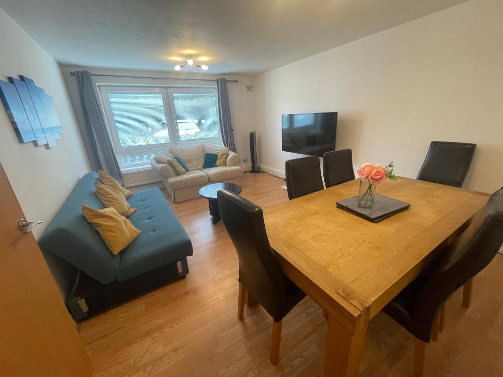 a living room with a dining room table and a couch at Spacious Apartment near Heathrow with Allocated Parking in Uxbridge