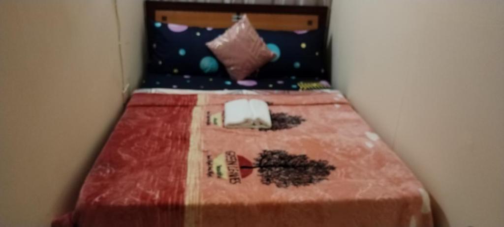 a small bed in a room with a red blanket at My Home Stay apartment 2 in Abu Dhabi