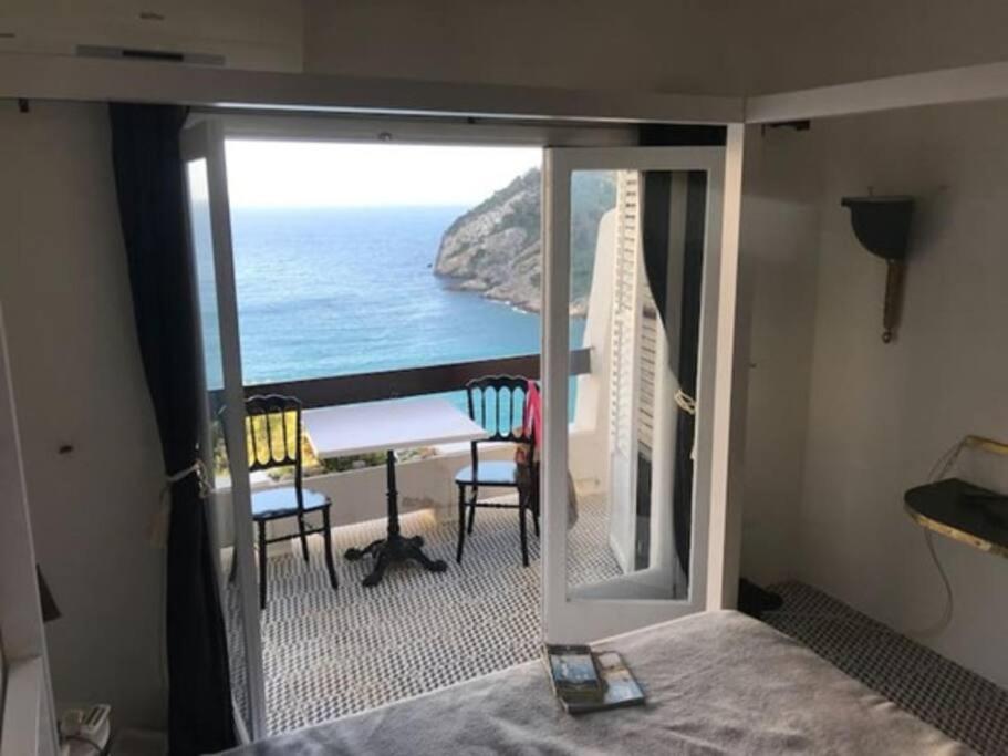 a room with a balcony with a view of the ocean at De Balearibus in Cala Llonga