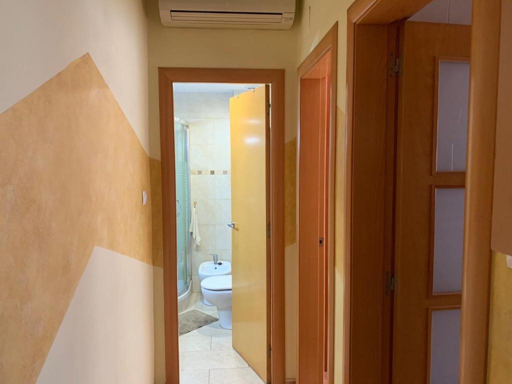 baño con aseo, lavabo y puerta en Apartamento Bàsico, en Cala Llonga