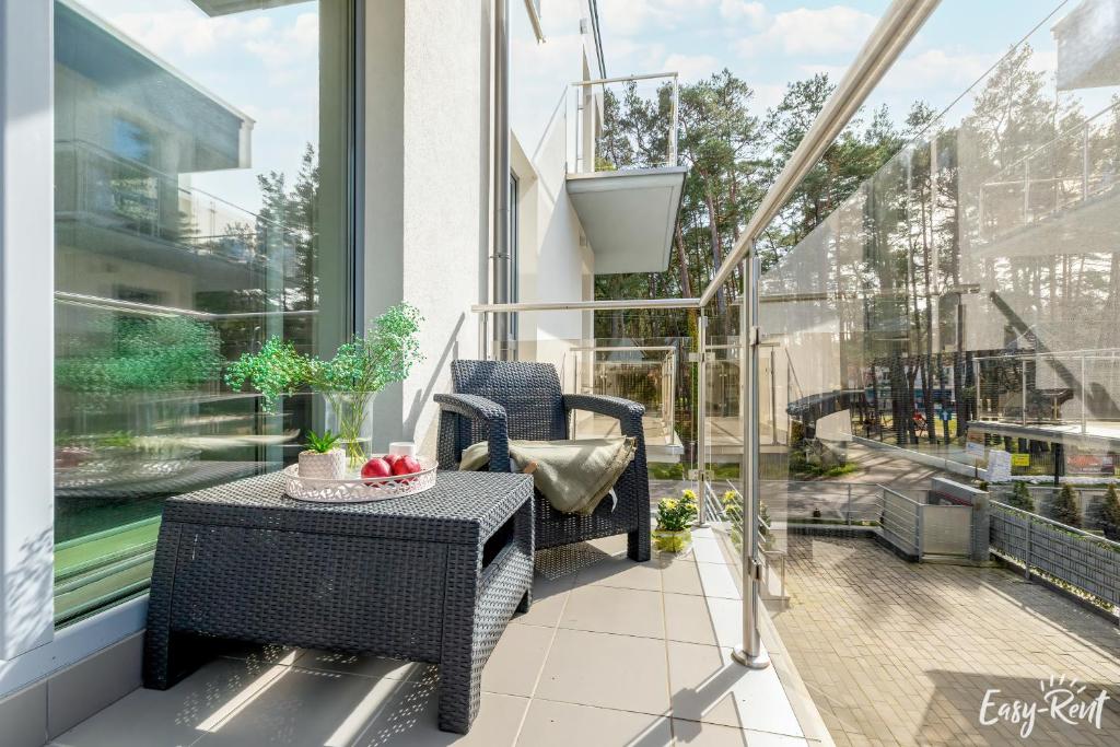 eine Terrasse mit einem Tisch und Stühlen auf dem Balkon in der Unterkunft Grunwaldzka 12 D13 - Easy-Rent Apartments 50m od plaży in Pobierowo