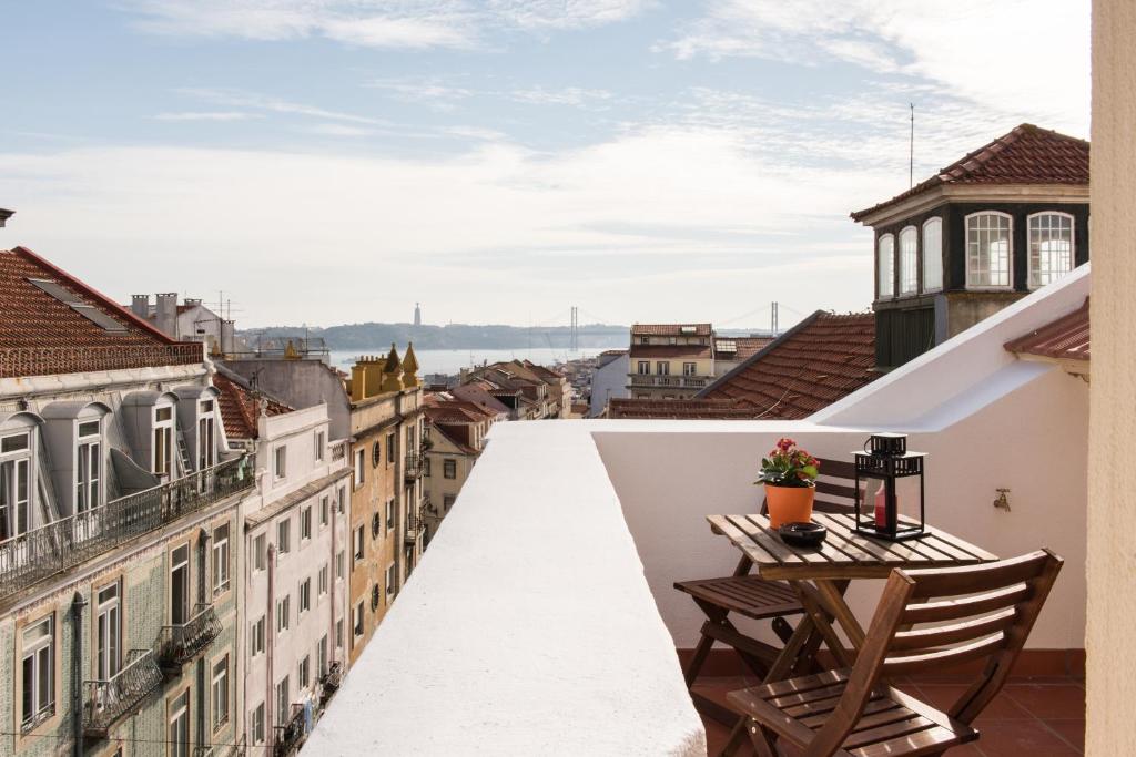 balkon ze stołem i krzesłami z widokiem na miasto w obiekcie Casa do Jasmim by Shiadu w Lizbonie