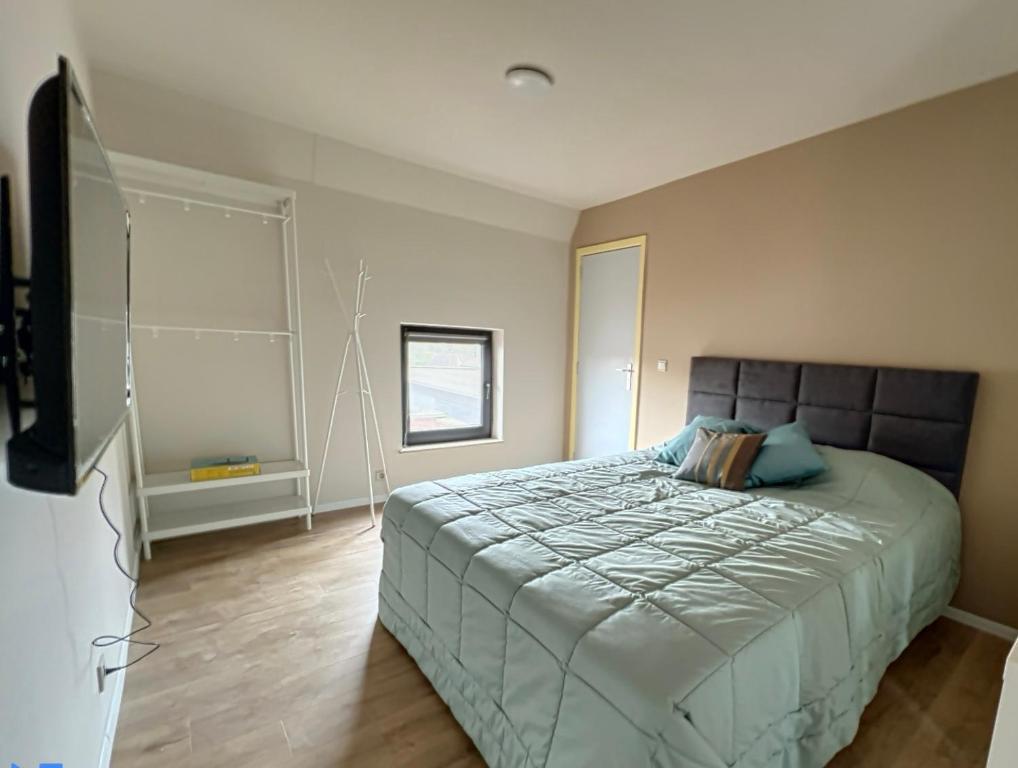 ein Schlafzimmer mit einem großen Bett und einem TV in der Unterkunft Station 64 A2 Bruxelles-Charleroi-airport in Charleroi