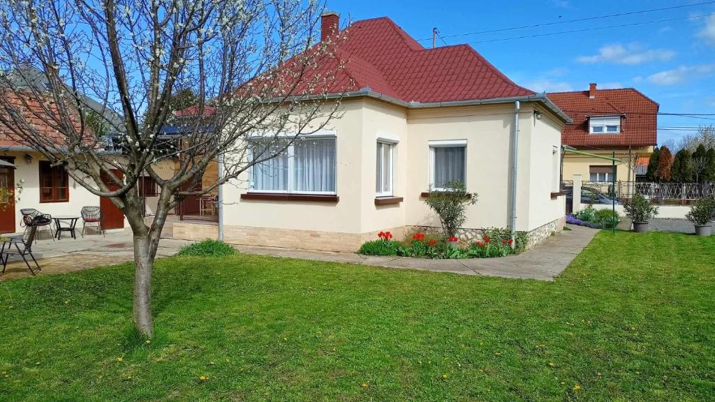 uma casa branca com um telhado vermelho num quintal em Neubauer Vendégház*** Mohács em Mohács