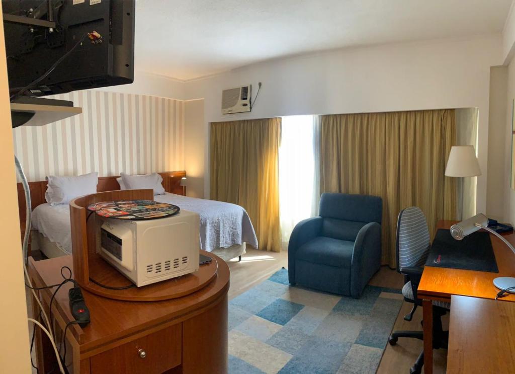 a hotel room with a bed and a tv on a dresser at Charmoso Flat na Vila Mariana in Sao Paulo