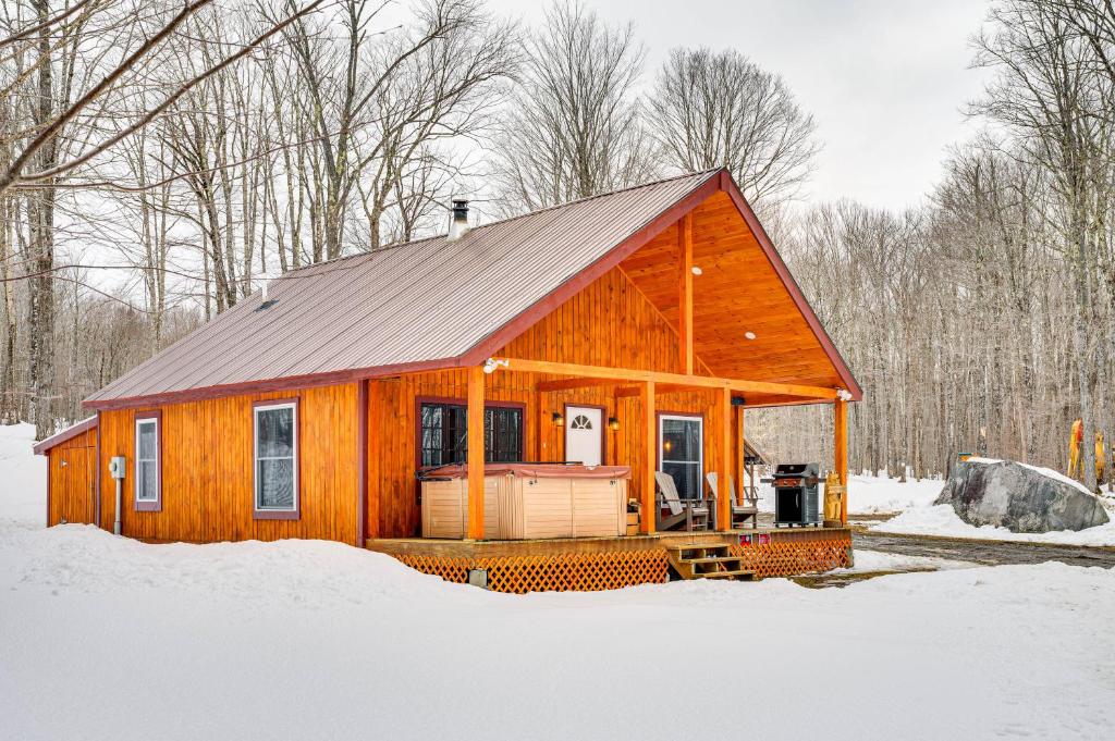 a wooden cabin in the snow in the woods at Magnificent Victory Cabin with Private Hot Tub! 