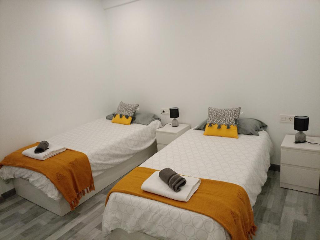 1 dormitorio con 2 camas y toallas. en Piso nuevo a 10 minutos de San Sebastián, en Lasarte