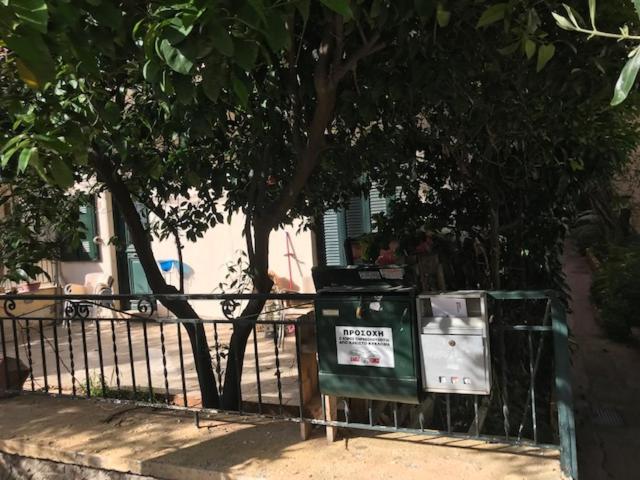 due bidoni della spazzatura seduti accanto a una recinzione di Palaio Faliro Plaza με Jacuzzi και Τζάκι ad Atene