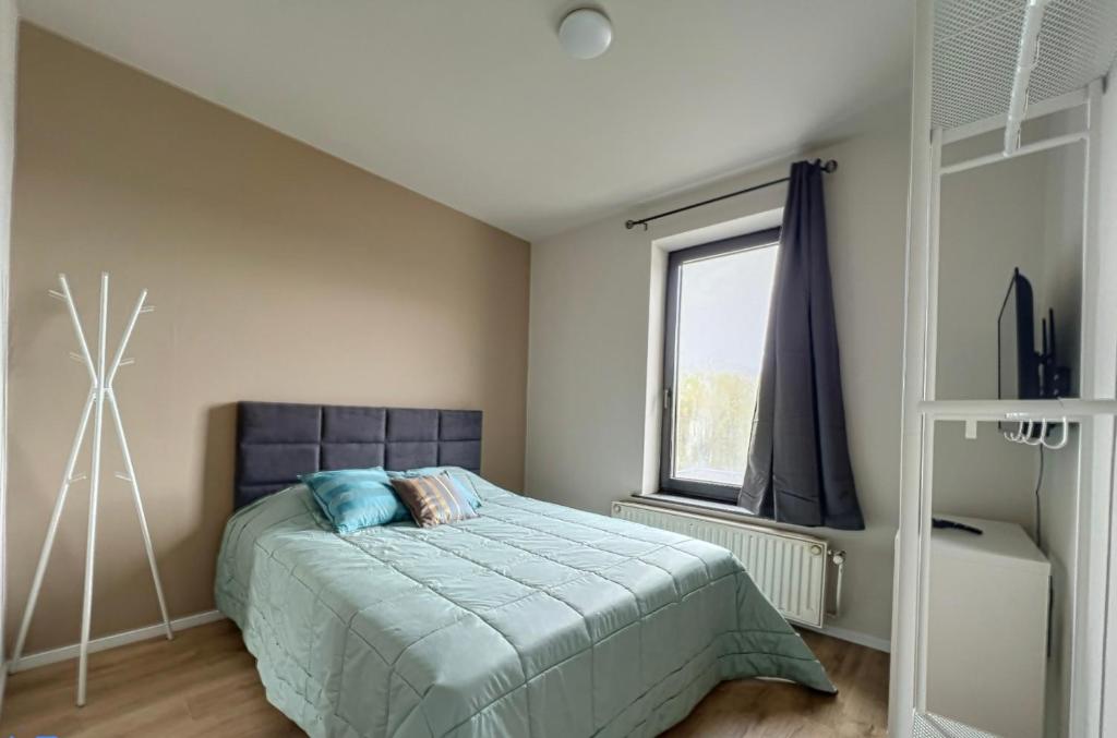 um quarto com uma cama e uma janela em Station 64 A4 Charleroi-Airport em Charleroi