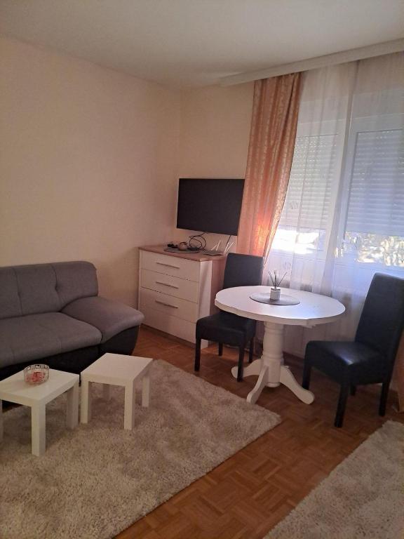a living room with a couch and a table at Lovely Apartment with terrace/Divan apartman sa terasom in Novo Selo