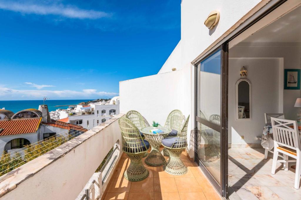 a balcony with a table and chairs and the ocean at Casa Cerro Branco in Albufeira