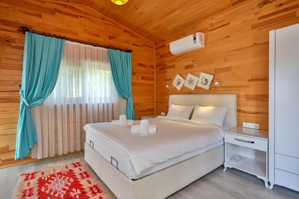 a bedroom with a bed and a desk and a window at Simge Pension in Cıralı