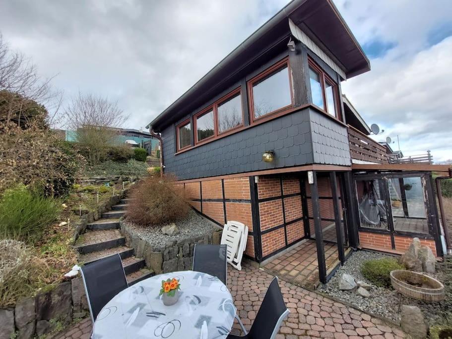 a house with a table and chairs in front of it at Ferienhaus Eifel Nature Dream II in Dockweiler