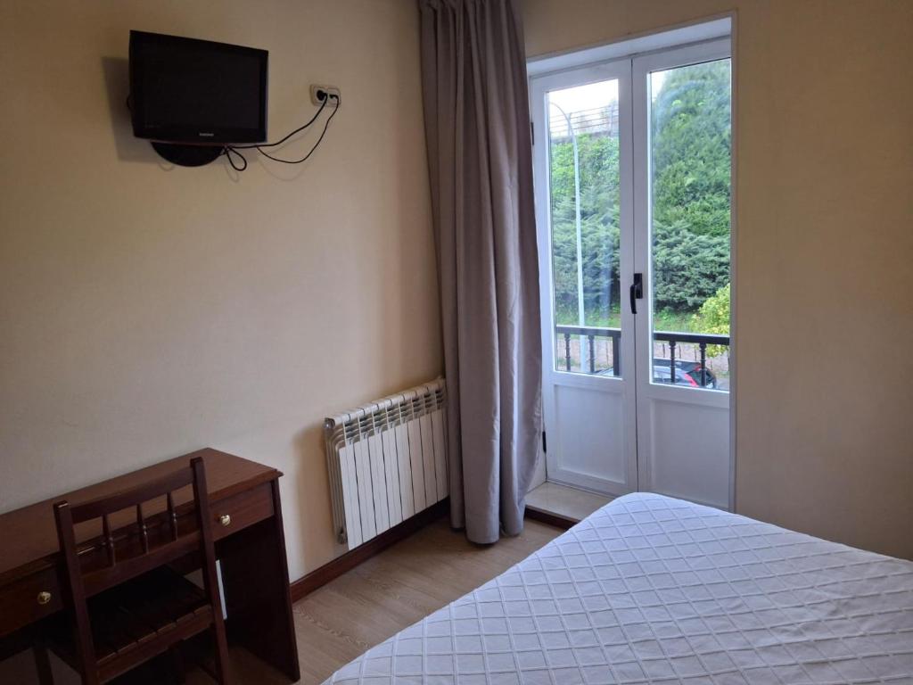 サンティアゴ・デ・コンポステーラにあるHotel Capital de Galiciaのベッドルーム1室(ベッド1台、壁掛けテレビ付)