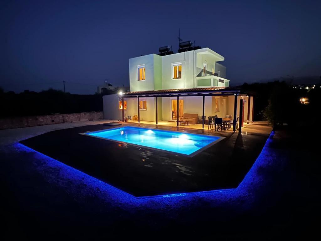 a villa with a swimming pool at night at Drosoula Villa 3bdr private swimming pool in Chorafakia