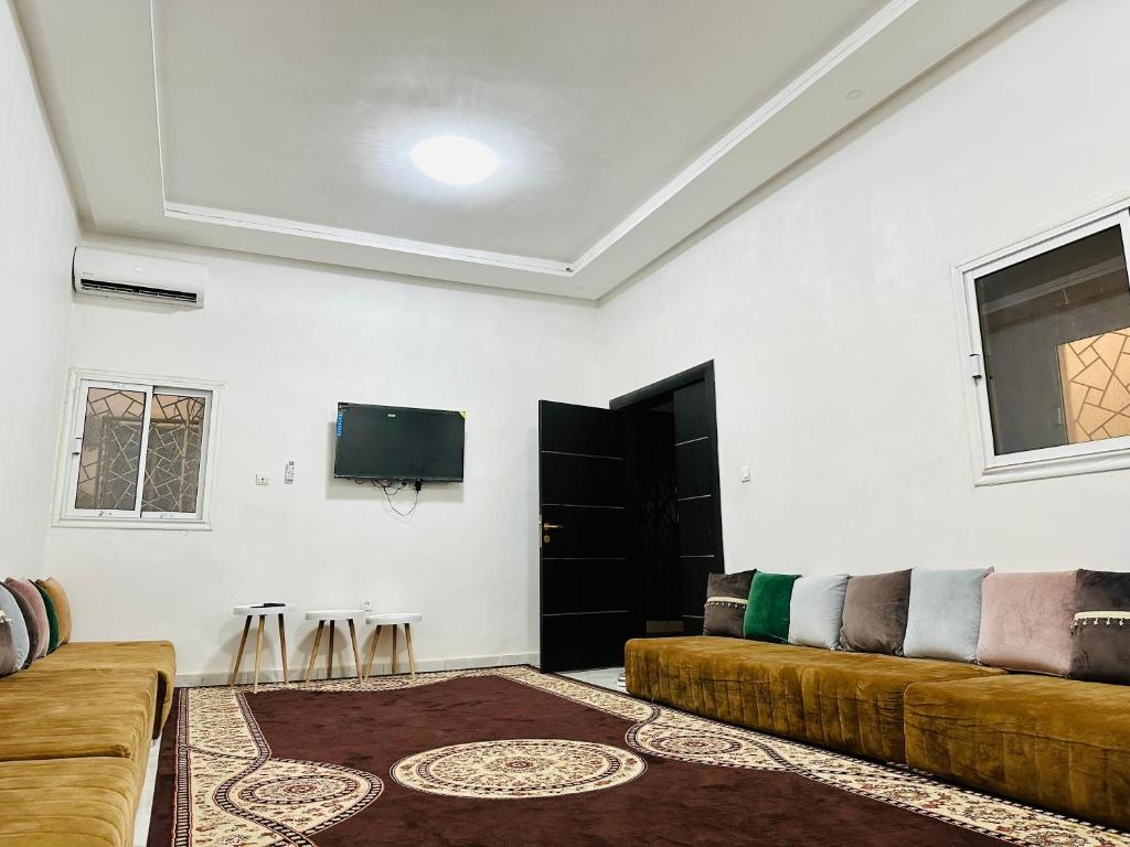 ein Wohnzimmer mit einem Sofa und einem Flachbild-TV in der Unterkunft Duplex neuf meublé in Nouakchott