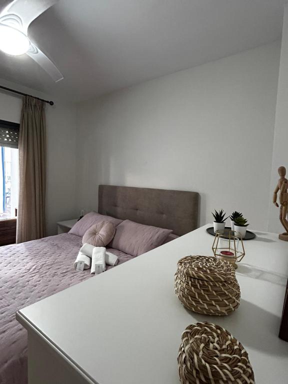 a white bedroom with a bed and a couch at Apartamento el Ermitaño in Chipiona