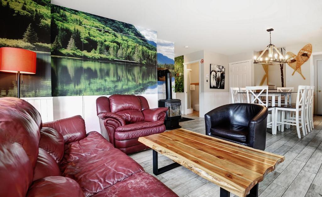 sala de estar con muebles de cuero y mesa en Chalets Alpins -11 Chemin Alpin, en Stoneham