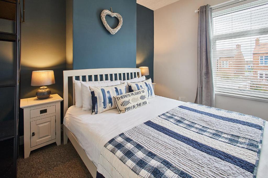 1 dormitorio con 1 cama con pared azul en Host & Stay - King Edward Terrace, en Marske-by-the-Sea