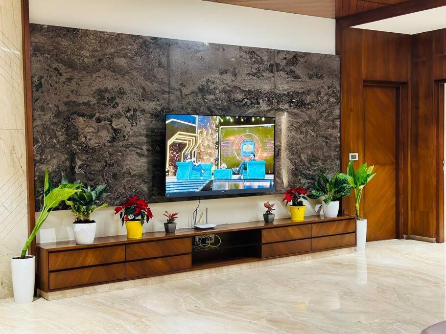 a living room with a television on a wall at Ultra luxury 5BHK duplex in Kondapur in Kondapur