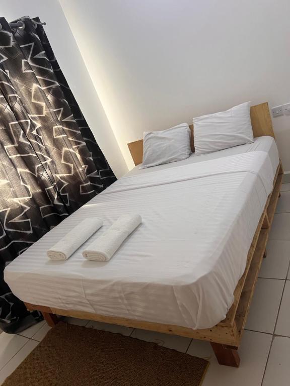 uma cama com duas toalhas brancas em cima em Gianna’s Stays em Mombasa