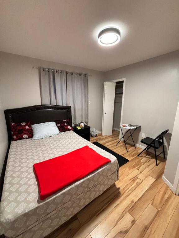een slaapkamer met een bed met een rode deken erop bij A very neat private room for one person only in Riverview