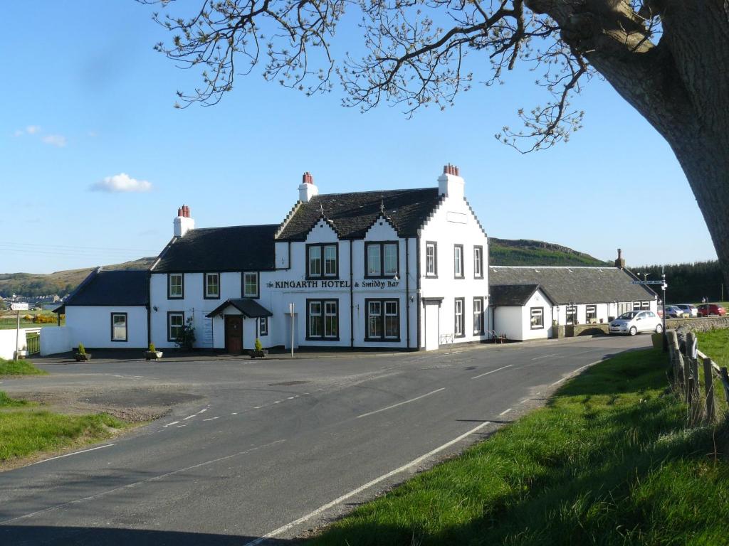 a white house on the side of a road at Kingarth Hotel in Kilchattan
