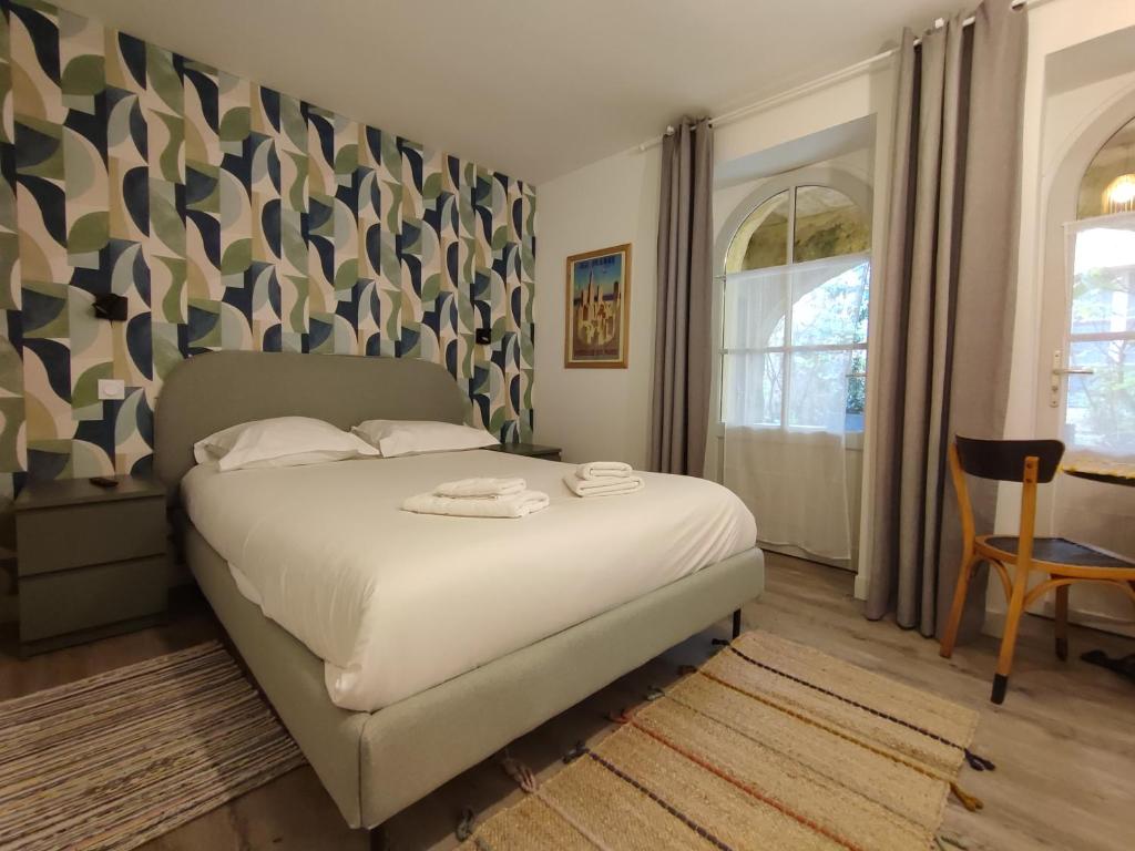 une chambre avec un lit blanc et une fenêtre dans l'établissement Studio sur patio au coeur des Chartrons, à Bordeaux