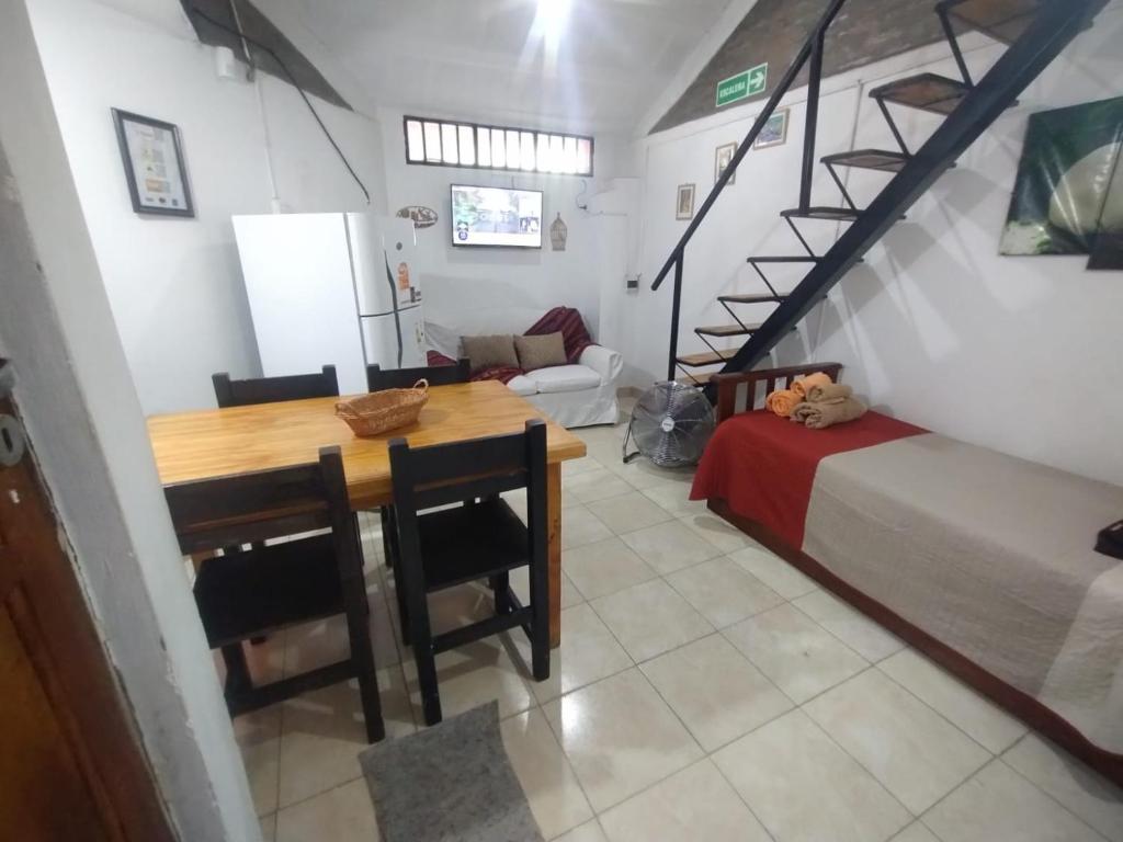 - un salon avec une table, un lit et un escalier dans l'établissement Bruna Departamentos, à San Fernando del Valle de Catamarca