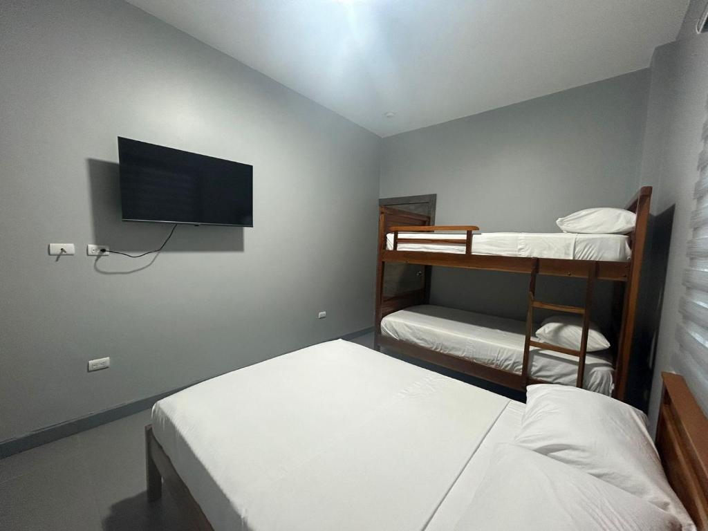 a room with two bunk beds and a flat screen tv at Hotel Ipanema Beach by Majestic in Salinas
