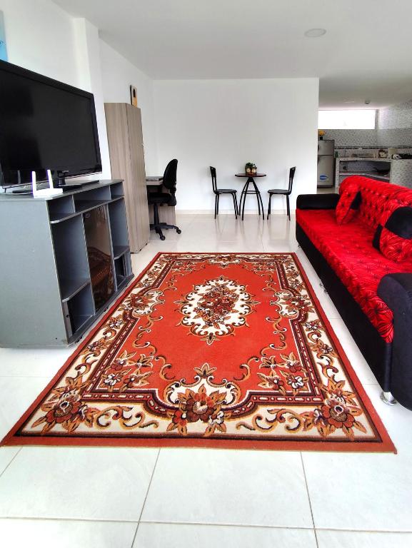 uma sala de estar com um sofá vermelho e um tapete vermelho em Hermoso apartamento en Popayán em Popayán