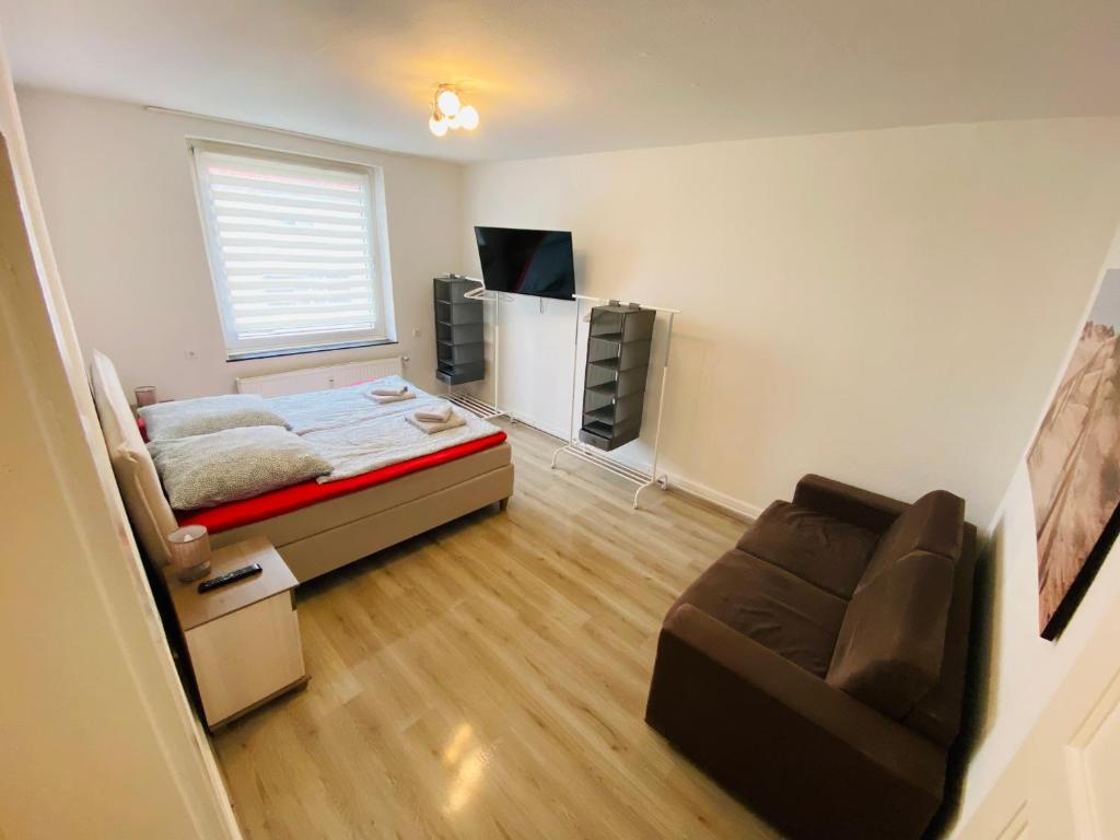 um pequeno quarto com uma cama e um sofá em Beautiful Apartment I 4 Beds I Fast WiFi I Kitchen em Bielefeld