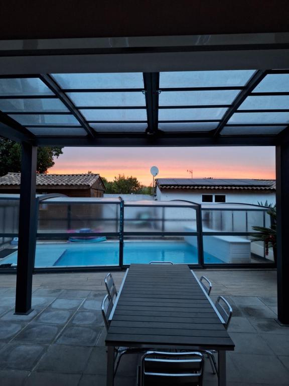 - une table et des chaises sur une terrasse avec piscine dans l'établissement Blue Maldives, à Argeliers