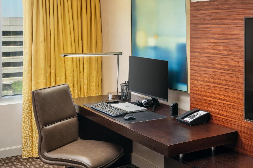 a desk with a computer and a chair in a room at Hilton Short Hills in Short Hills