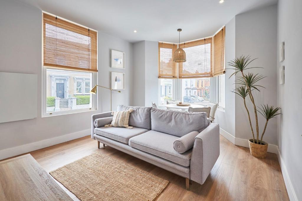 uma sala de estar com um sofá e duas janelas em Host & Stay - Poplar Villas em Ramsgate