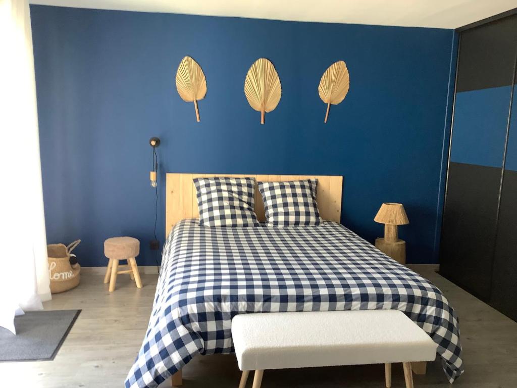 een blauwe slaapkamer met een bed met een geruite deken bij Le Caux ´Sy in Senneville-sur-Fécamp