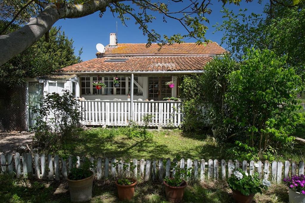 een wit huis met een hek ervoor bij Atypical house near ARLES, Camargue in Fourques