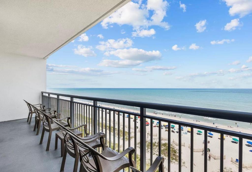 a balcony with chairs and a view of the beach at Ocean View Blues- Caribbean Resort 7th fl in Myrtle Beach