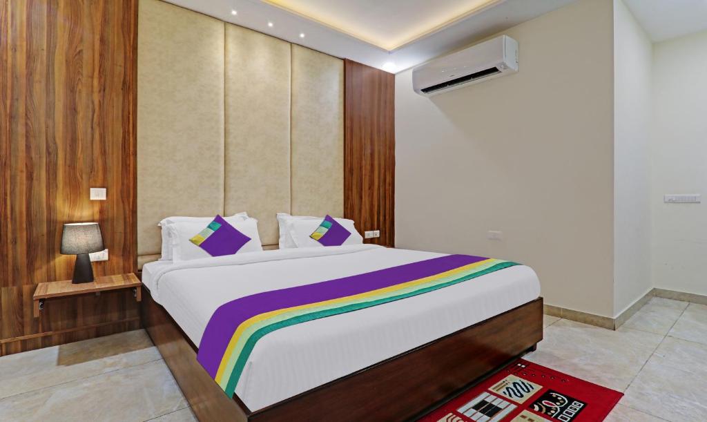a bedroom with a bed with a rainbow blanket at Hotel Golden Palace in Agra