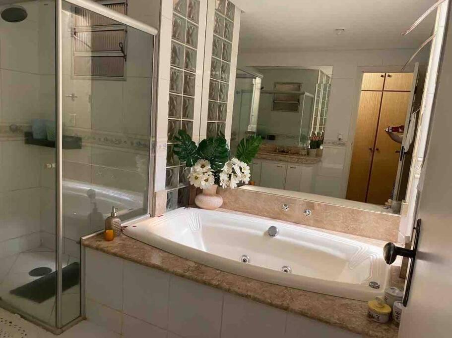 a bath tub in a bathroom with a mirror at Apartamento Encantador C in Montes Claros