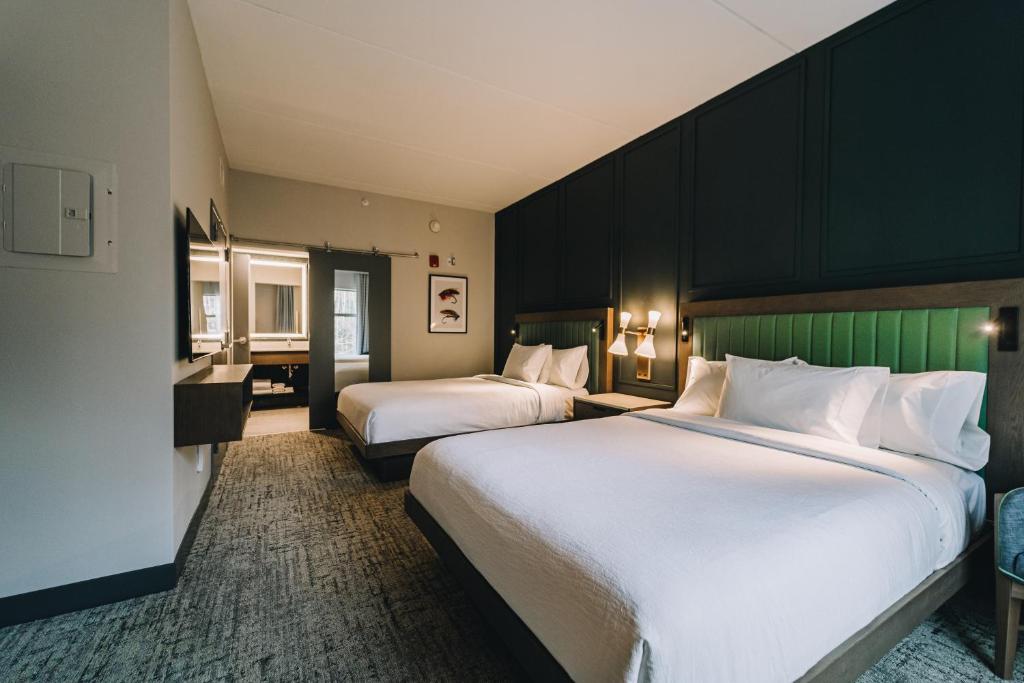 ein Hotelzimmer mit 2 Betten und einem Schreibtisch in der Unterkunft Embassy Suites By Hilton Gatlinburg Resort in Gatlinburg