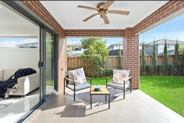 a patio with two chairs and a ceiling fan at Happy life in Schofields