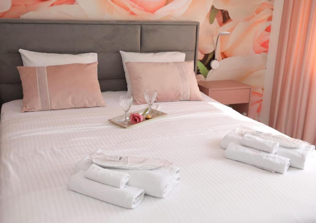 un letto bianco con due asciugamani e un vassoio sopra di Imedio Velvet Apartment Aviatiei a Bucarest