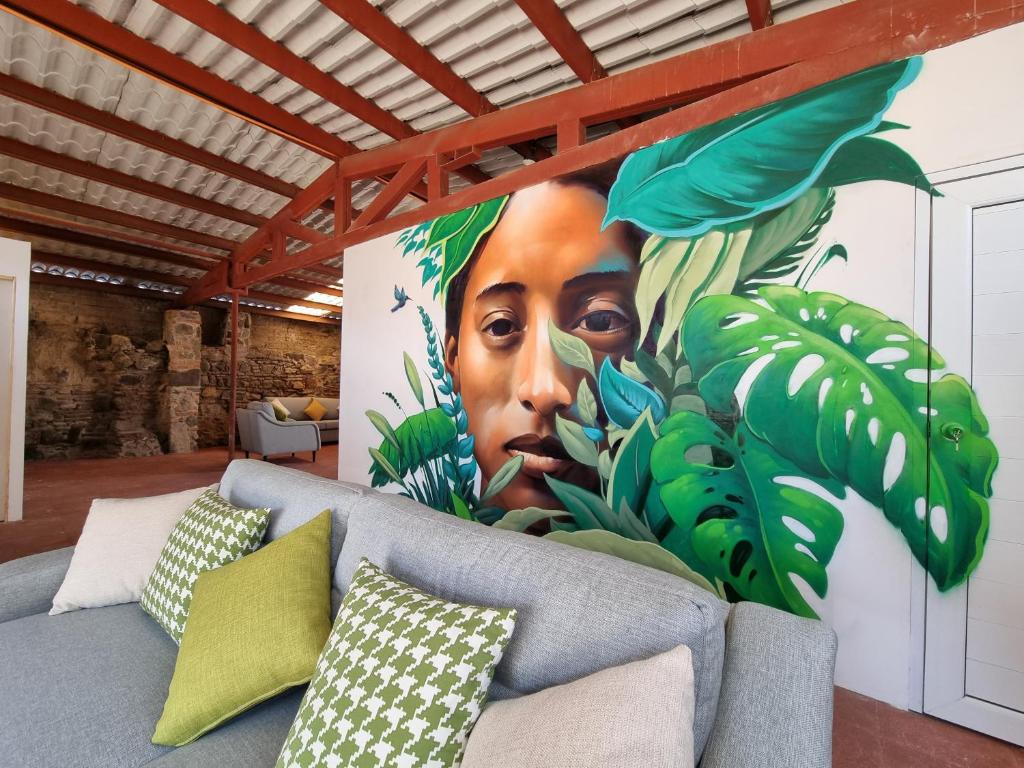 a mural of a woman with leaves on a wall at Central Hostel San Sebastian in Antigua Guatemala