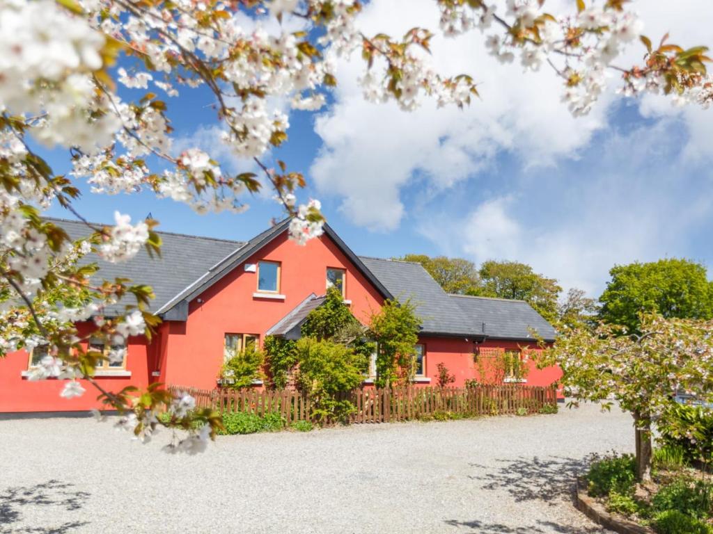 una casa roja con techo negro en Cherrygarth Cottage, en White Hall