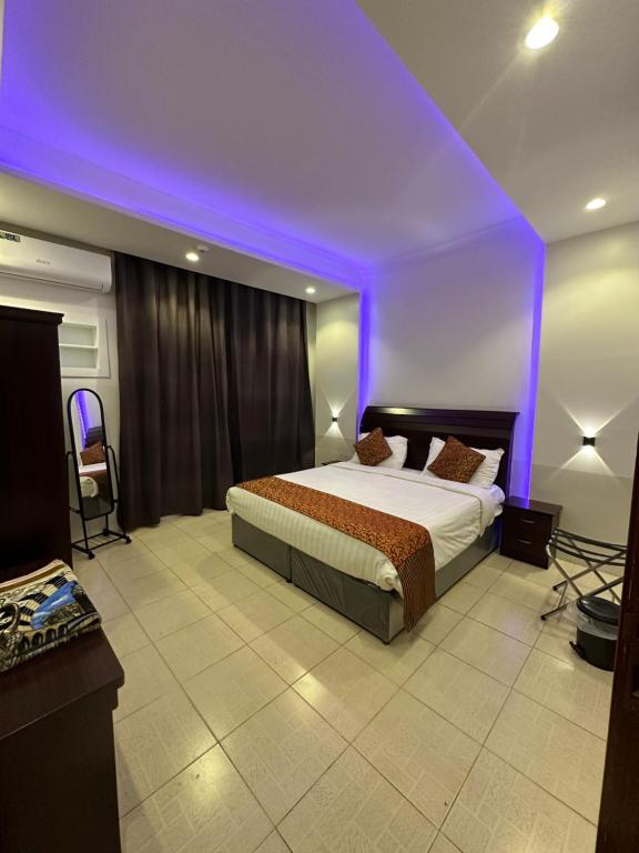 um quarto com uma cama com um tecto roxo em الديوان النجدي للشقق المخدومة em Ukaz