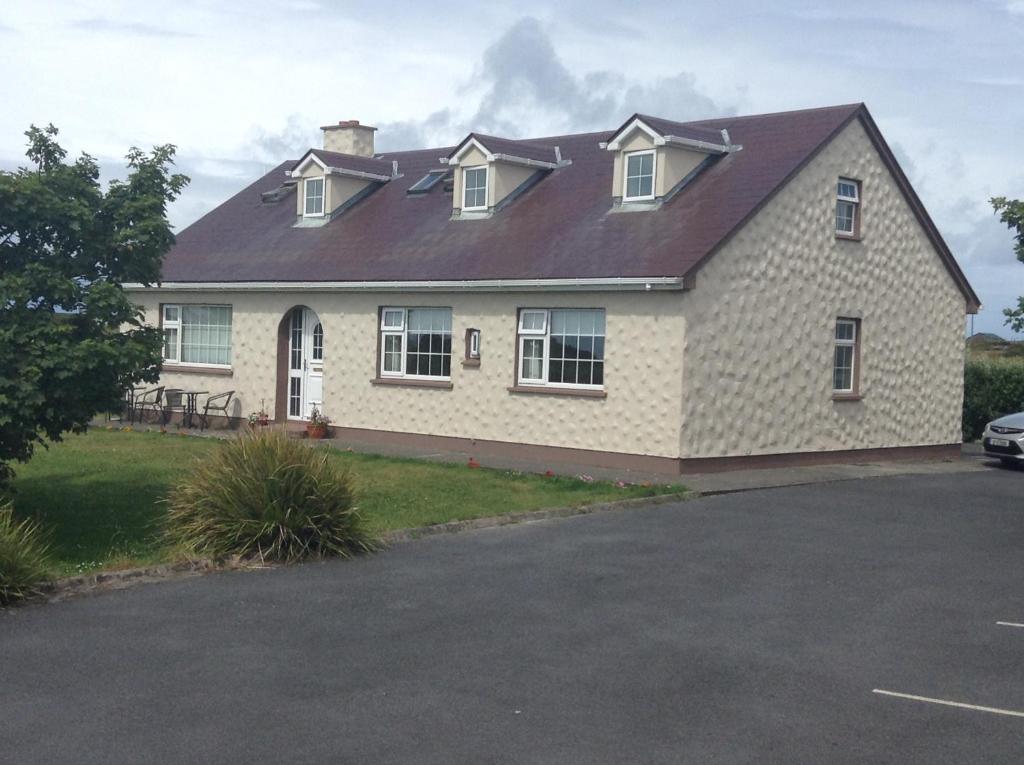 a house with a metal roof on a driveway at Doonhill Lodge in Galway