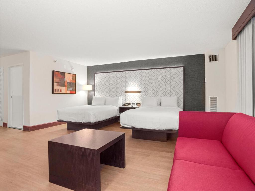 ein Hotelzimmer mit 2 Betten und einem Sofa in der Unterkunft Armon Hotel & Conference Center Stamford CT in Stamford