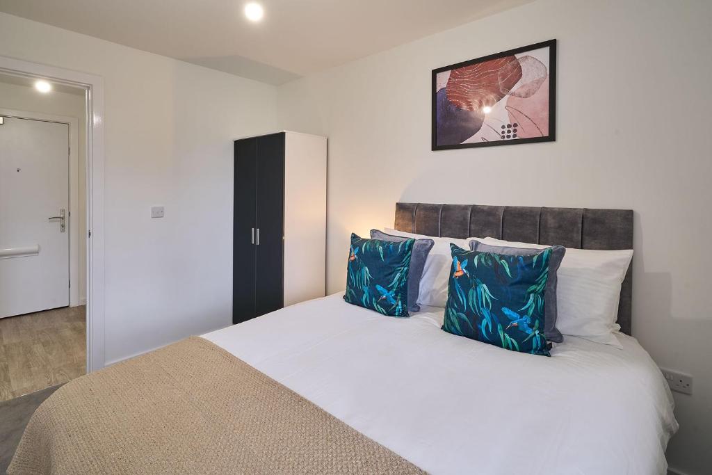 a bedroom with a large white bed with blue pillows at Host & Stay - 23 Waterside Place in Taunton