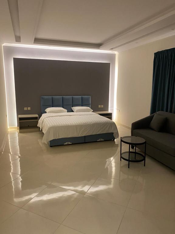 a bedroom with a bed and a couch at شقق ضيافة رغد 2 in Al Madinah